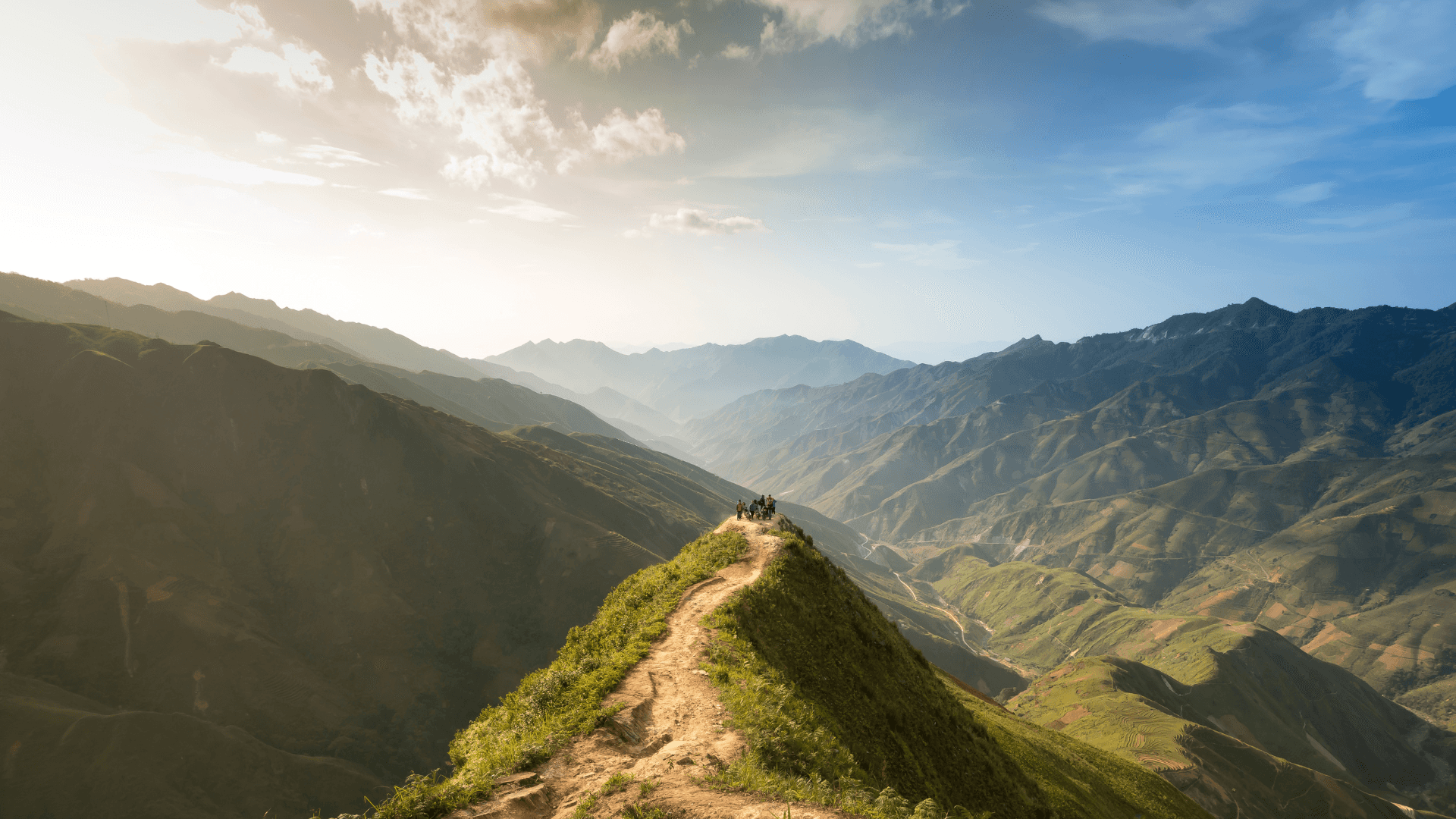 Protect the environment today! Background — Hikers traverse a sunlit mountain ridge overlooking endless green valleys under a bright blue sky with scattered clouds.