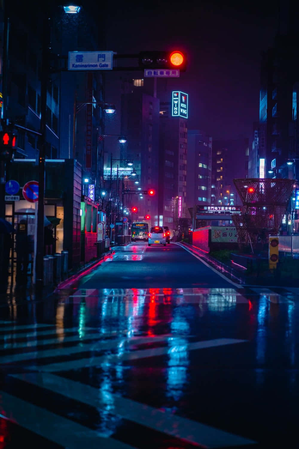 A City Street At Night With A Red Light Wallpaper