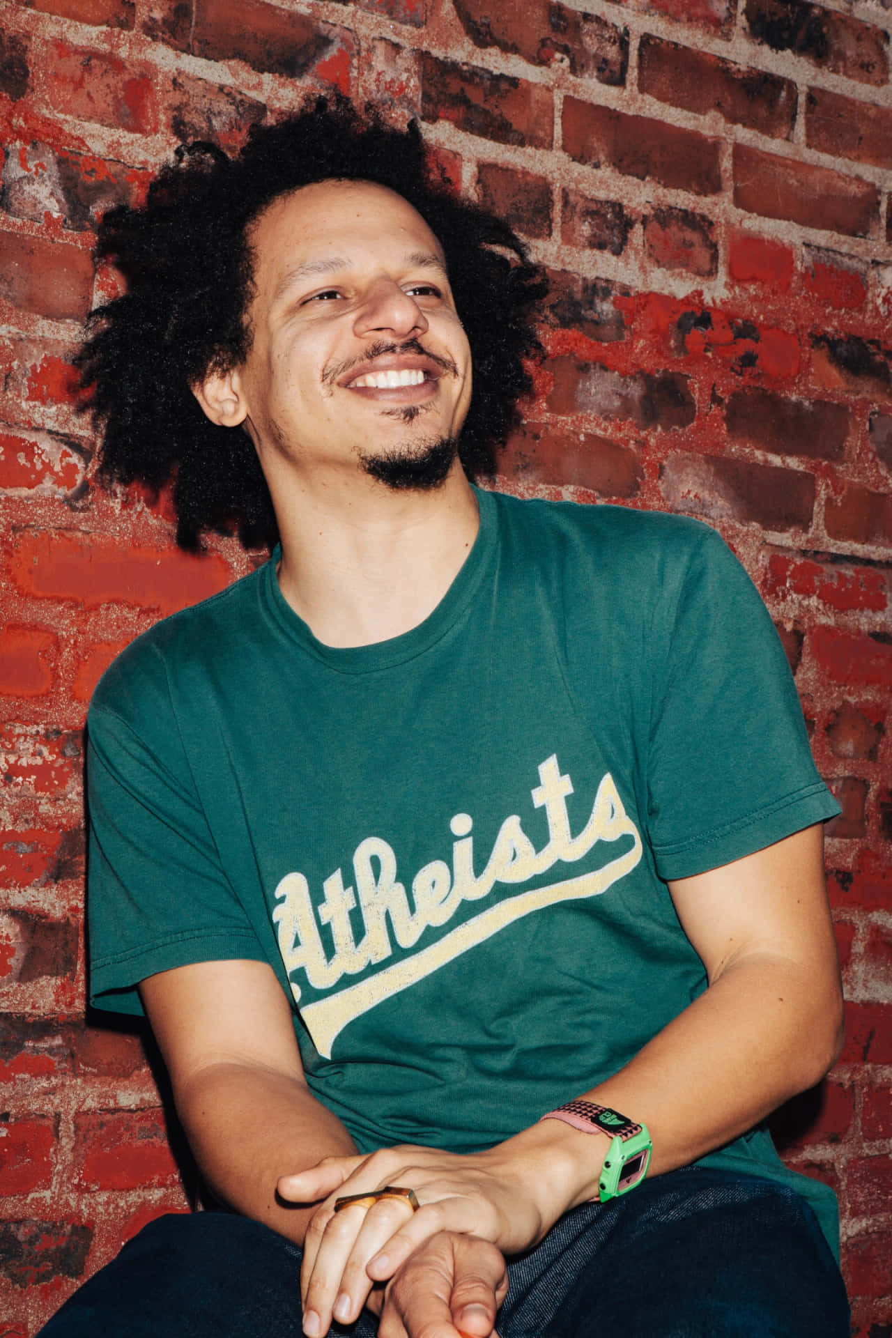 Eric Andre Smiling Brick Wall Background Wallpaper