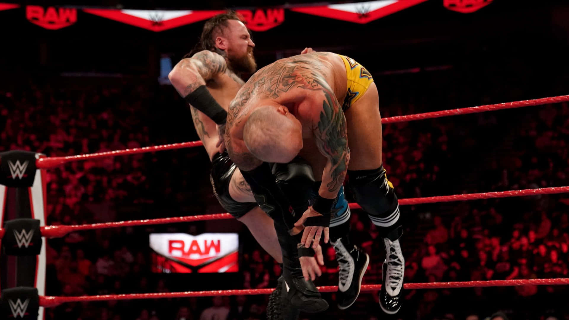 Eric Young Flipped by Aleister Black in a Wrestling Match Wallpaper