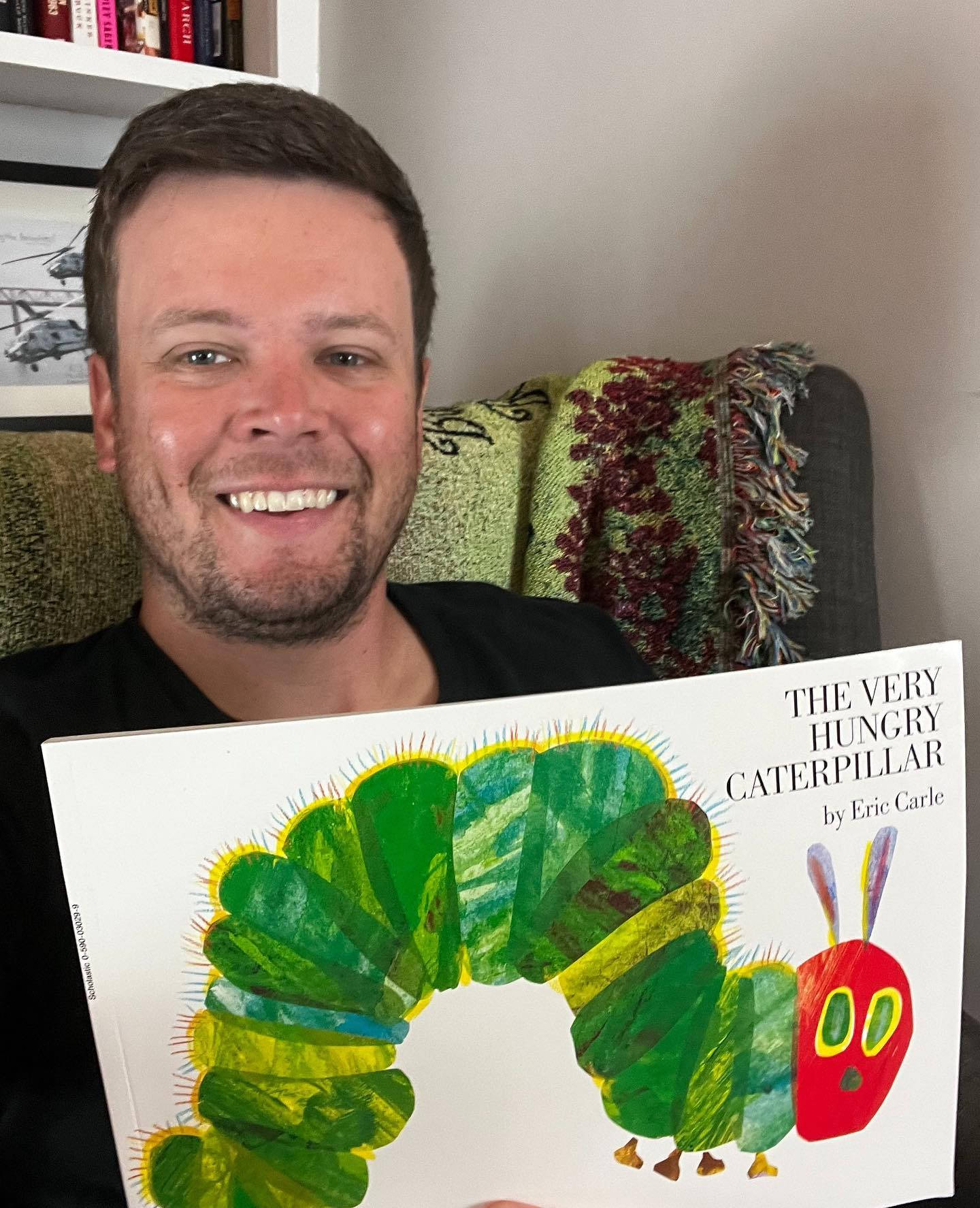Erik Jones With A Book Entitled "the Very Hungry Caterpillar" Wallpaper