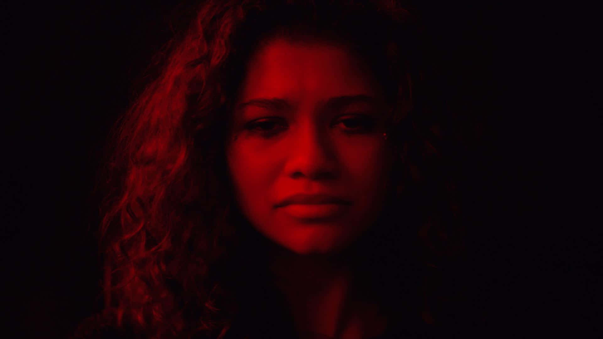 A Woman With Curly Hair In A Dark Room