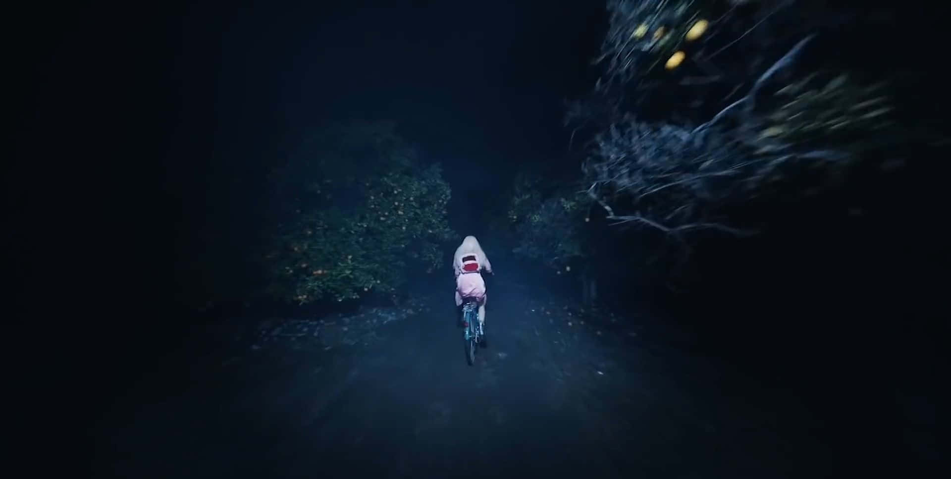 A Girl Riding A Bike Through The Dark Wallpaper