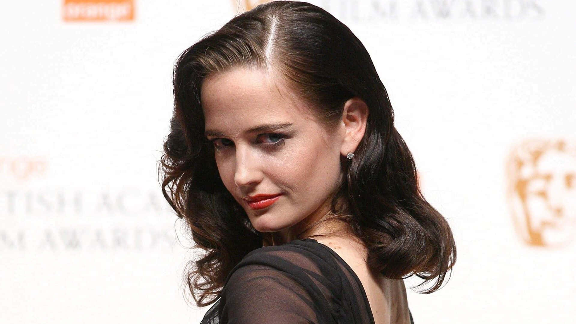 Eva Green Posing Elegantly in a Chic Outfit Wallpaper