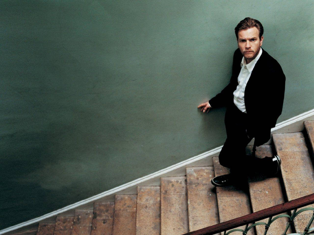Ewan McGregor Studiously Walking Down The Stairs Wallpaper