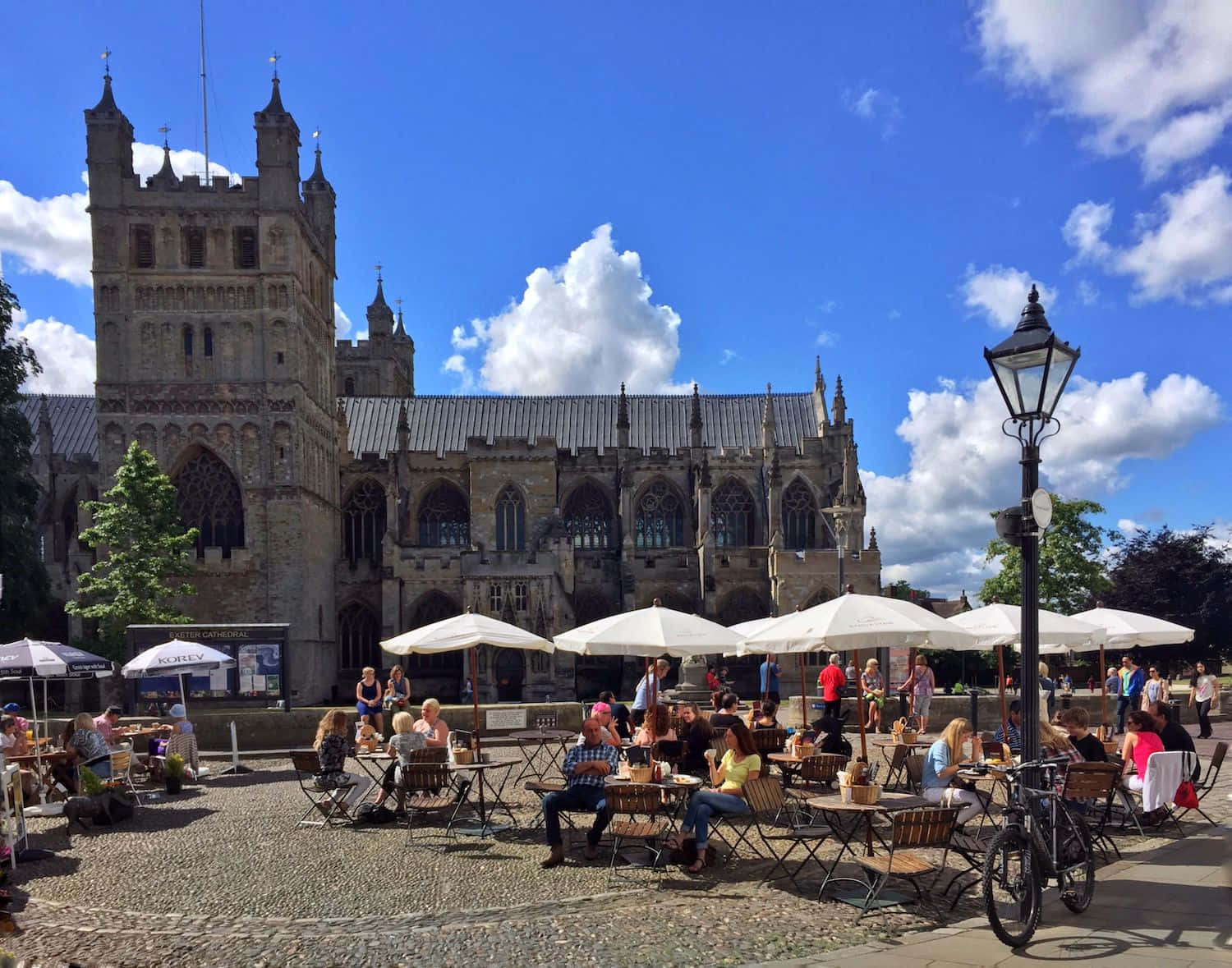 Utendørs Kafé Ved Exeter-katedralen På En Solfylt Dag Bakgrunnsbildet