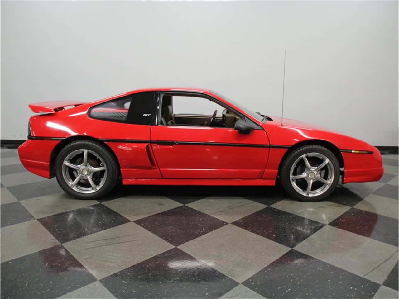 Eye-catching Red Pontiac Fiero Against Skyline Wallpaper