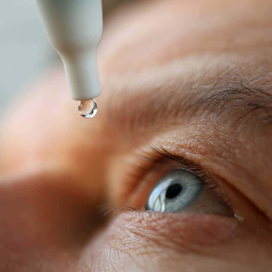 A Person's Eye Is Being Drained With A Drop Of Water