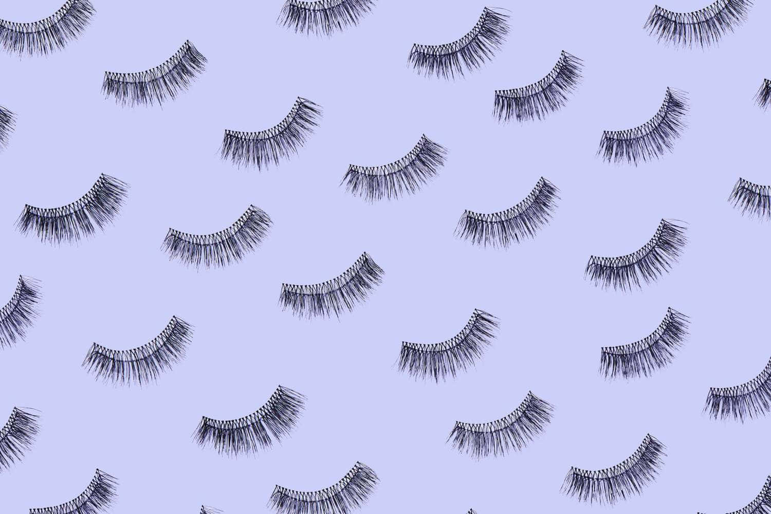 A Pattern Of False Eyelashes On A Purple Background