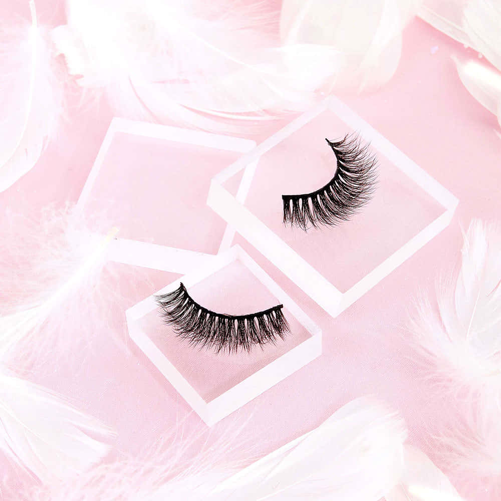 A Pair Of False Eyelashes On A Pink Background