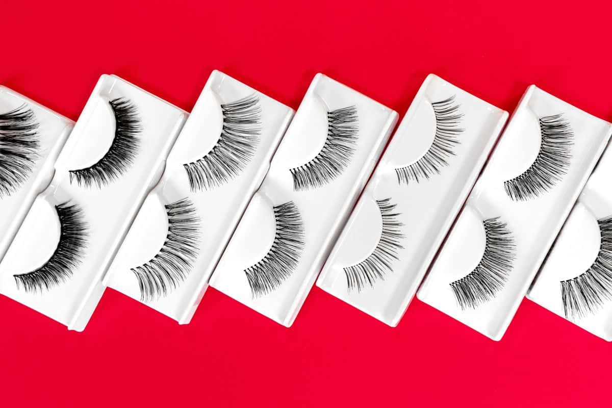 A Row Of False Eyelashes On A Red Background