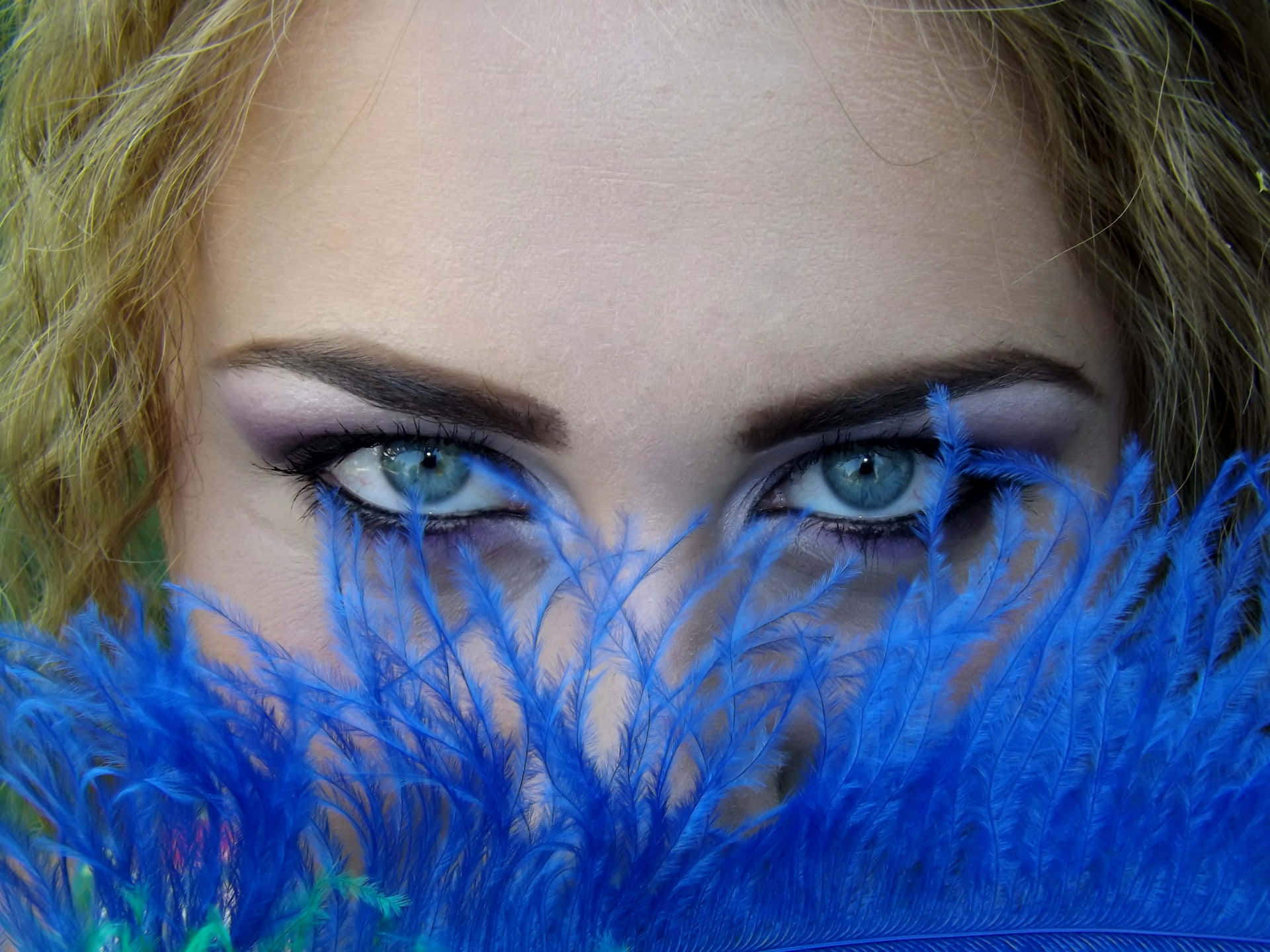 Mujercon Ojos Azules Detrás De Una Imagen De Pompones.