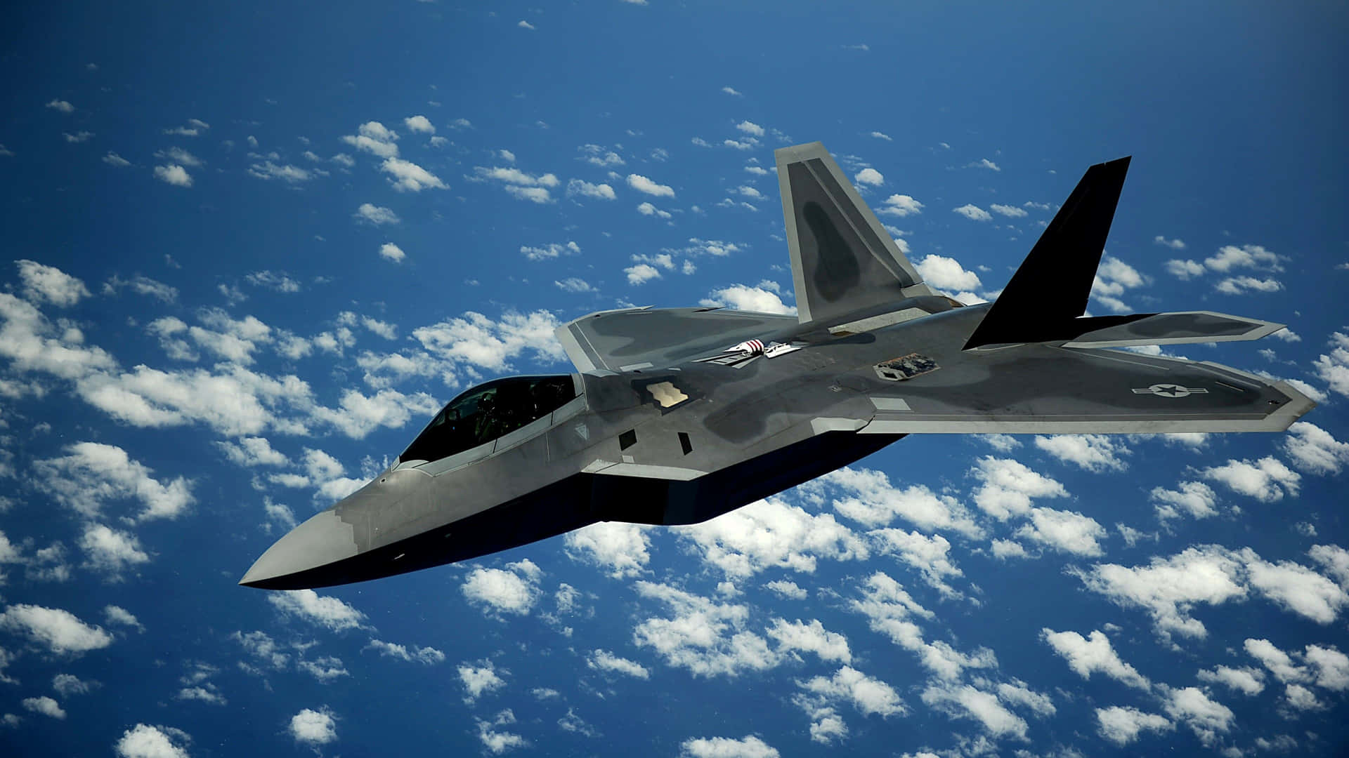 Den F-22 Raptor flyver smidigt gennem himlen Wallpaper