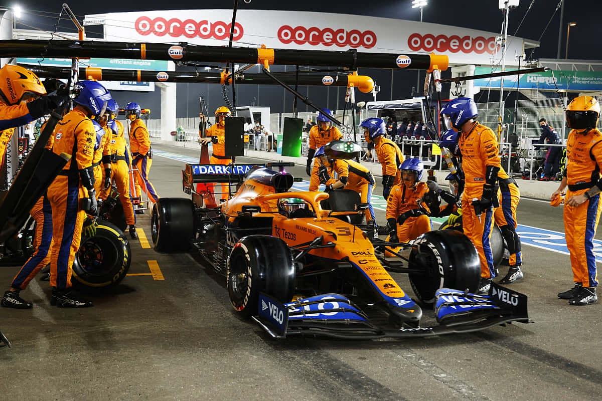 A Group Of People Working On A Racing Car