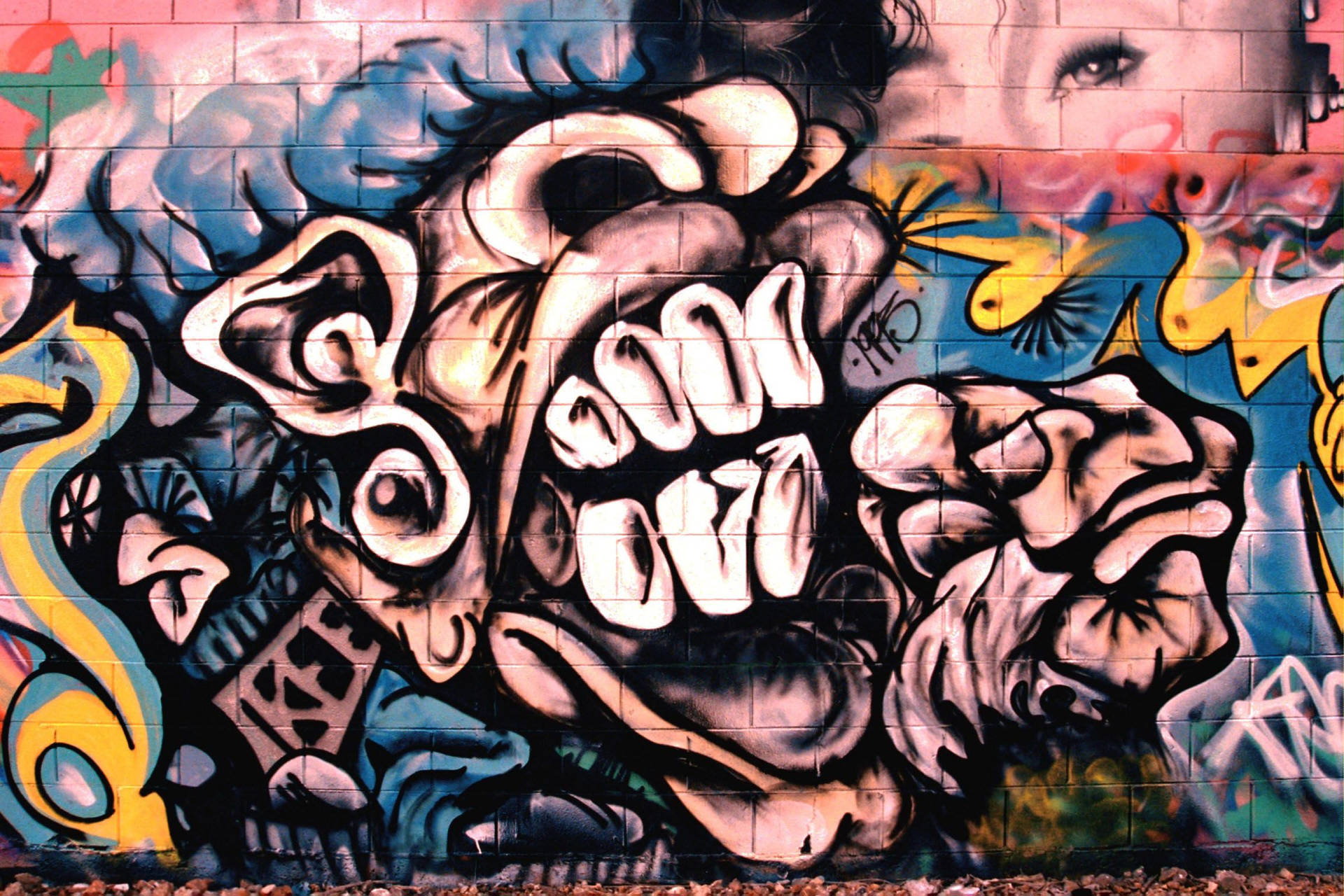 Graffiti wallpaper of huge human mouth with prominent teeth and female eye.