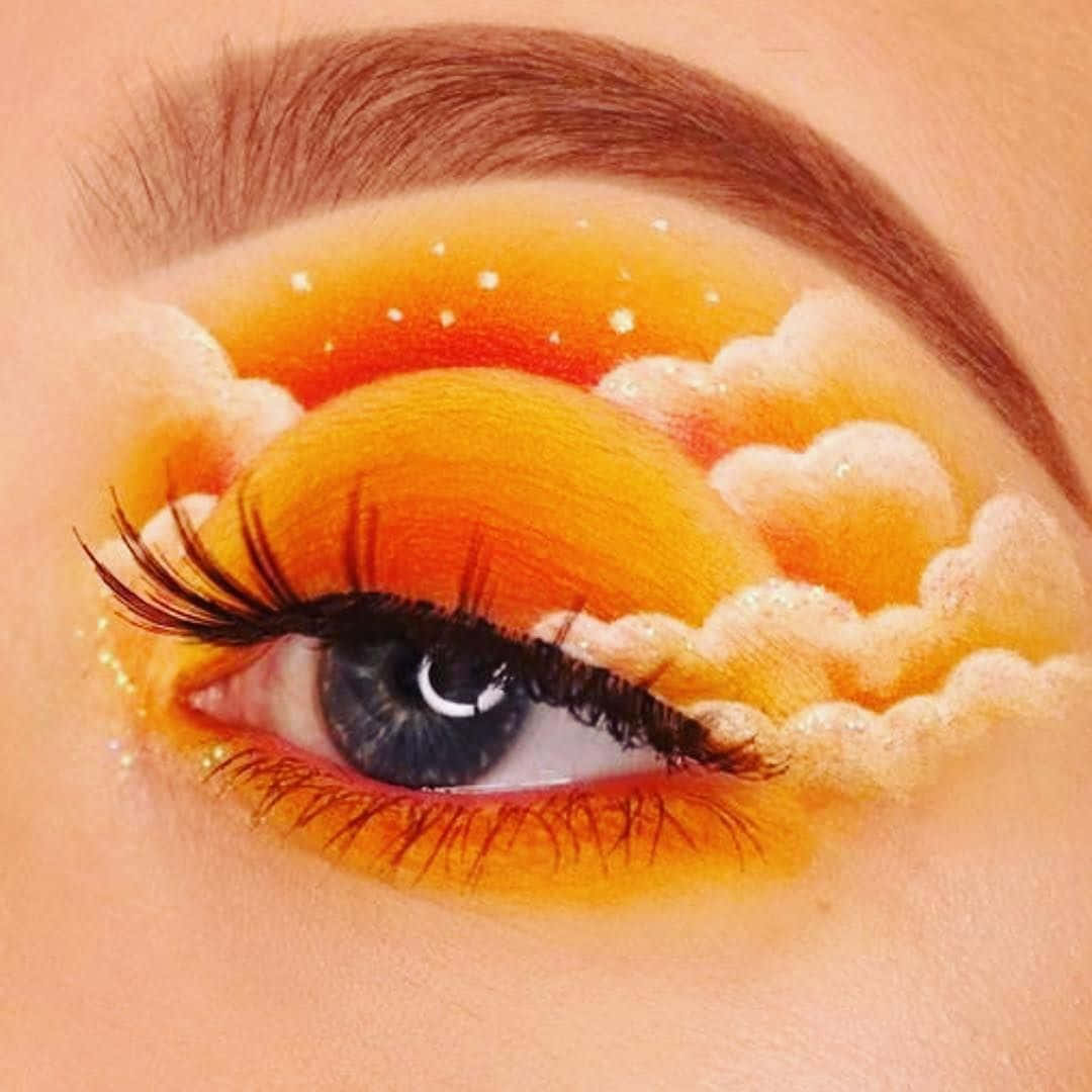 A Woman's Eye With A Cloud And Sun Painted On It