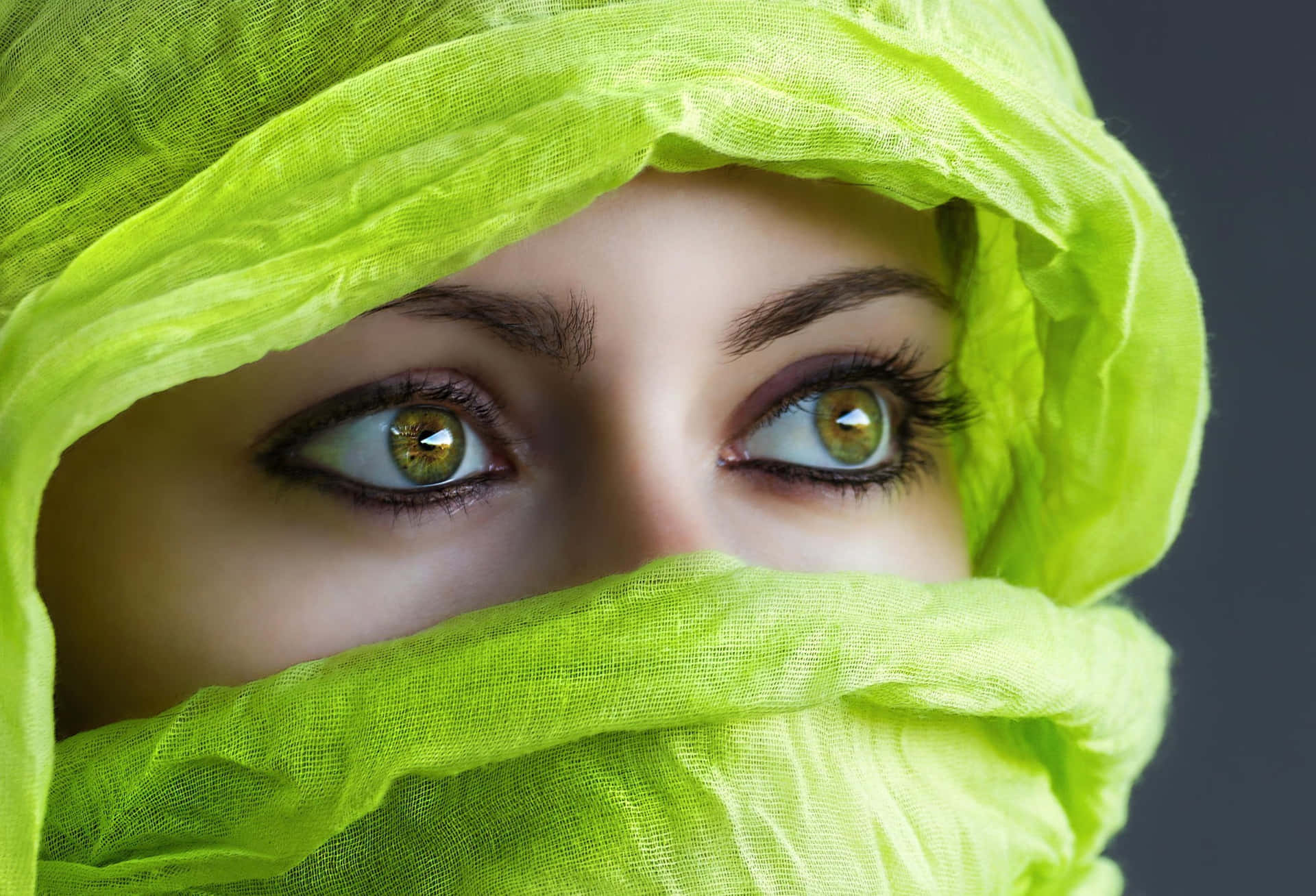 A Woman With Green Eyes Wearing A Scarf