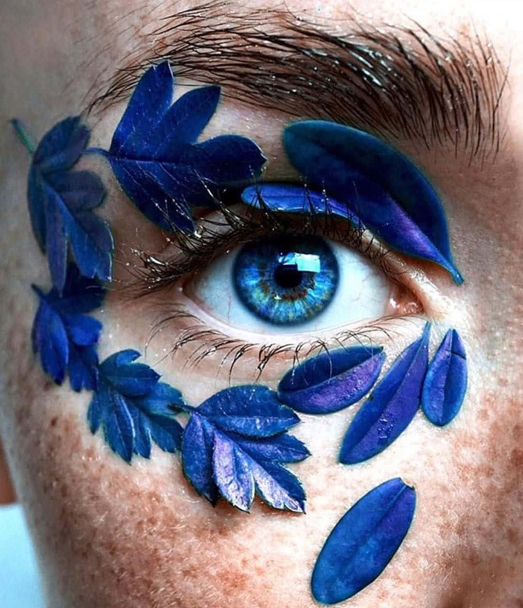 A Woman's Eye With Blue Leaves On It