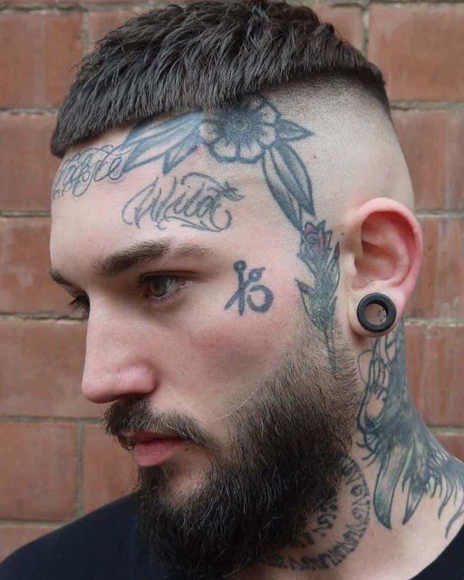 A Man With Tattoos And A Beard