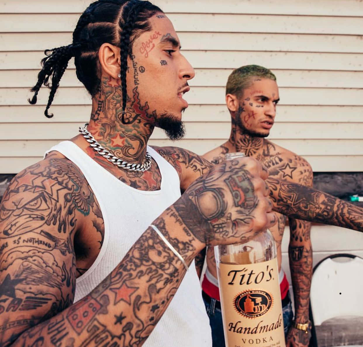 Two Men With Tattoos Standing Next To Each Other