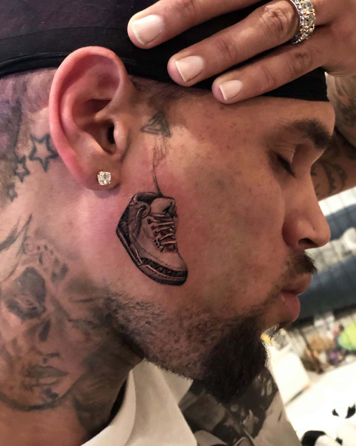 A Man With A Tattoo Of A Shoe On His Head