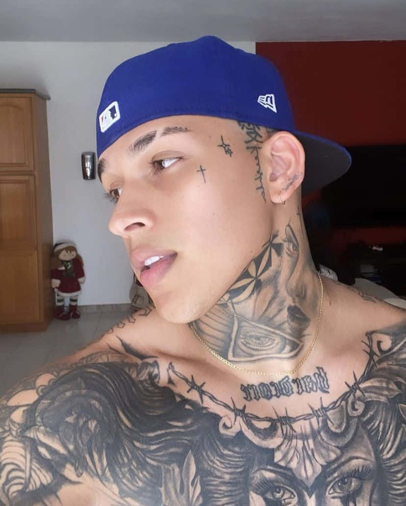 A Man With Tattoos On His Chest And Hat