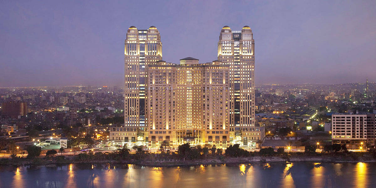 Caption: Mesmerizing view of the Fairmont Nile City Cairo Hotel at Sunset Wallpaper