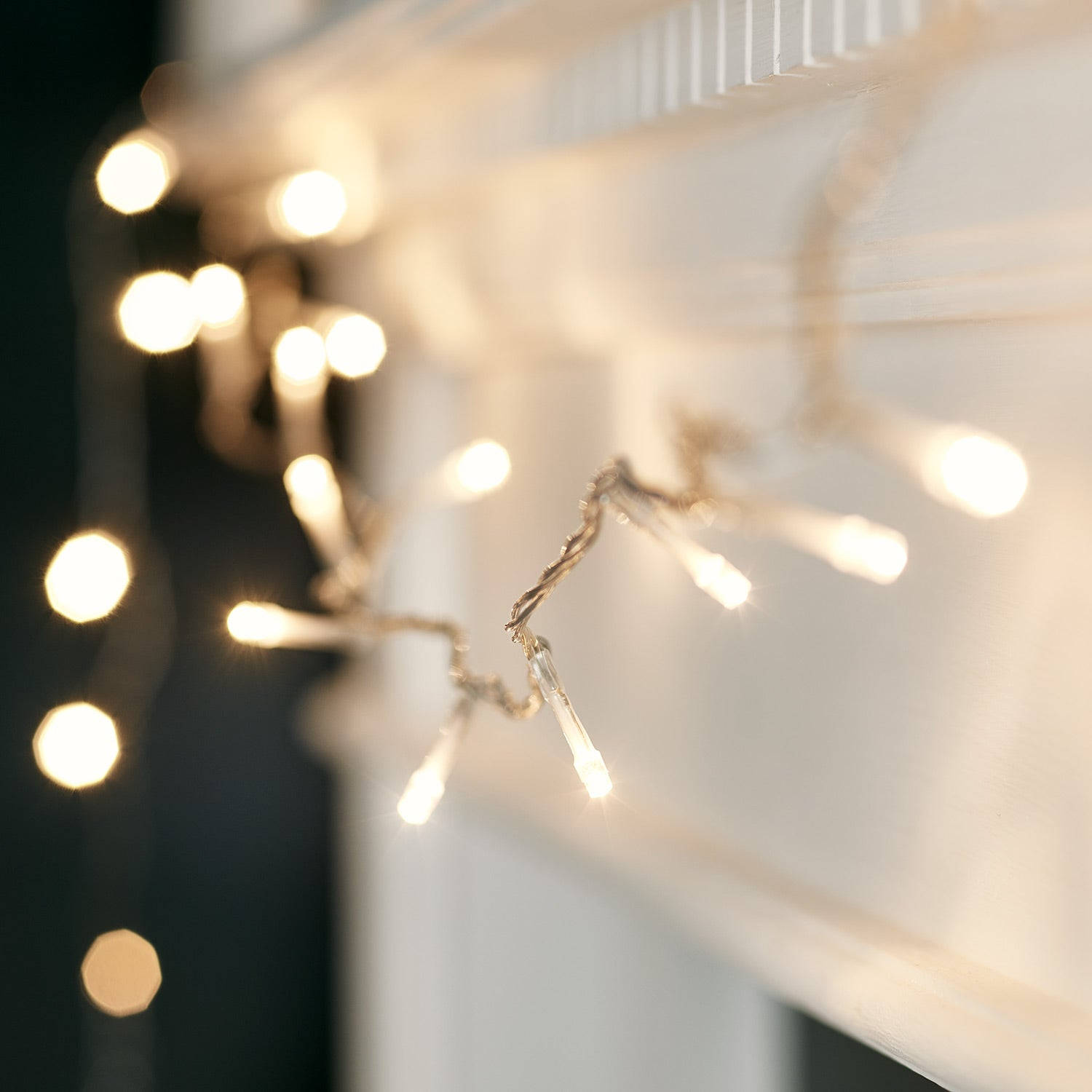 A Mantle With A String Of Lights Hanging From It Wallpaper