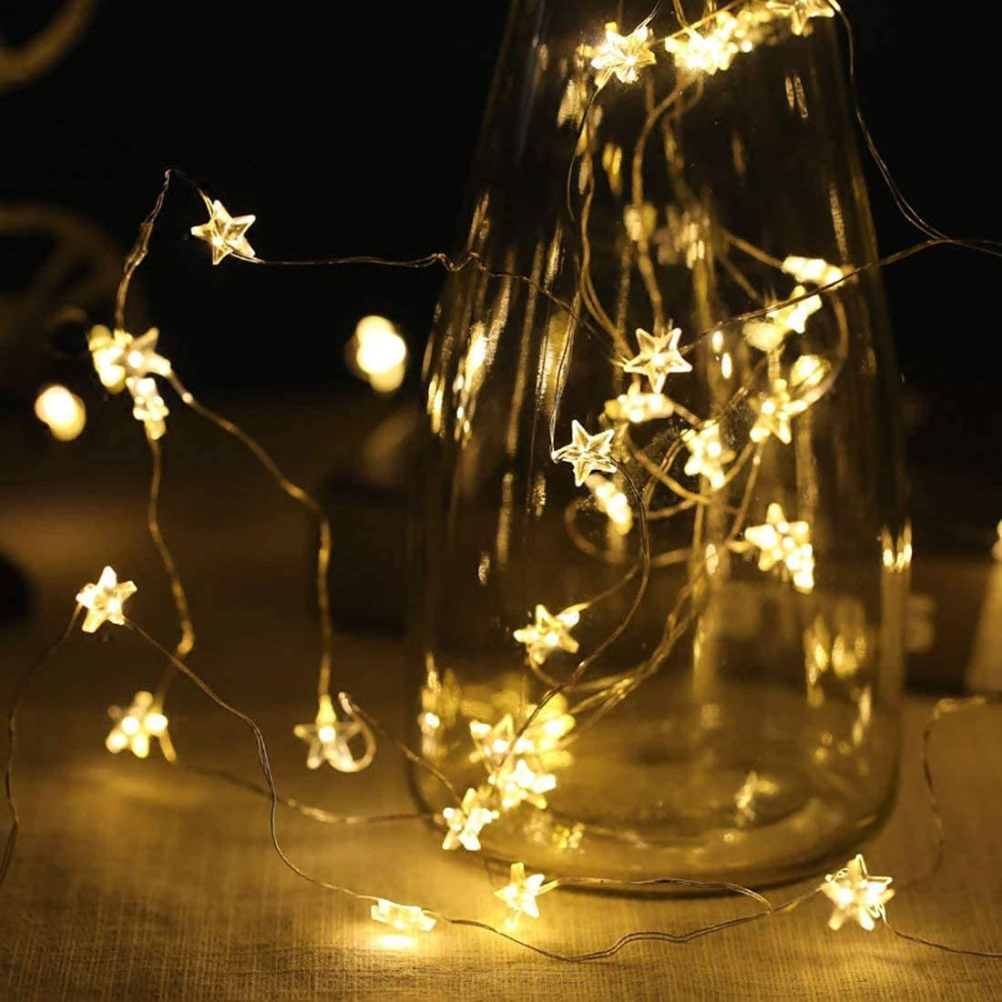 A Glass Vase With A Star String Light Wallpaper