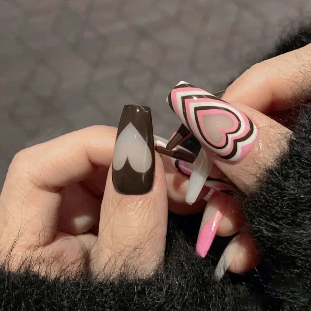 A Woman Holding A Pink And Black Heart Shaped Nail