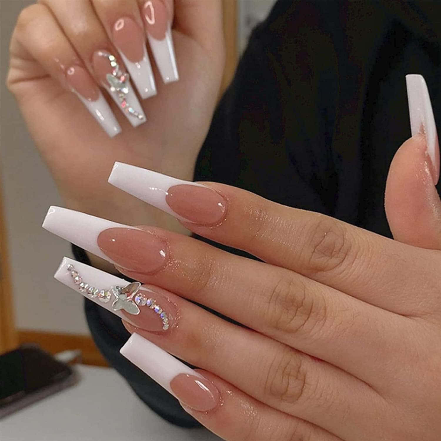 A Woman With White And White Nails Holding Up A White Nail