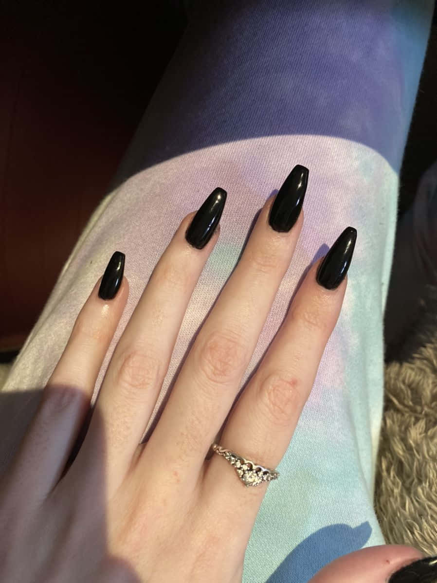 A Woman With Black Nails And A Ring