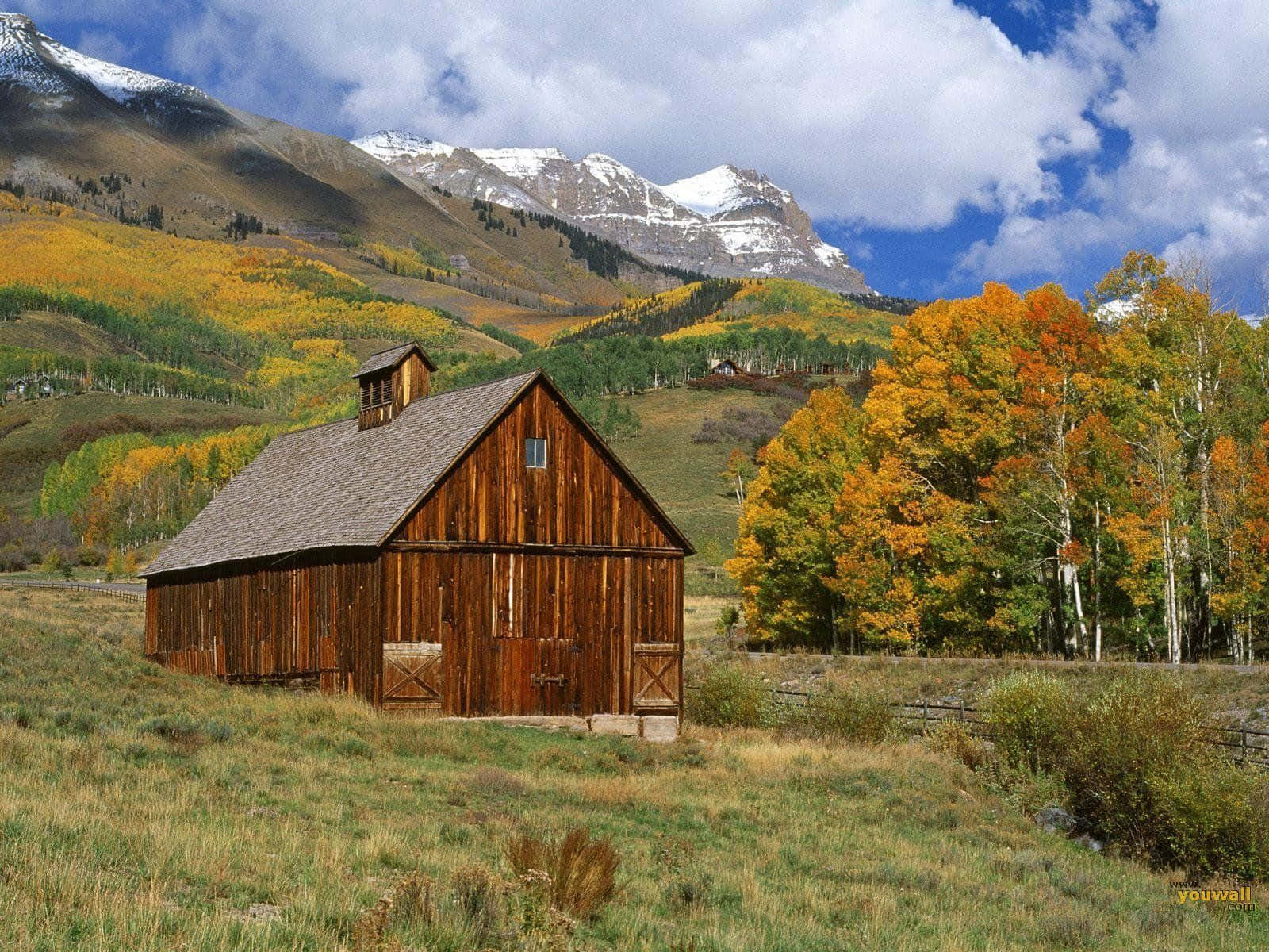 A picturesque Fall Barn surrounded by vibrant autumn foliage Wallpaper