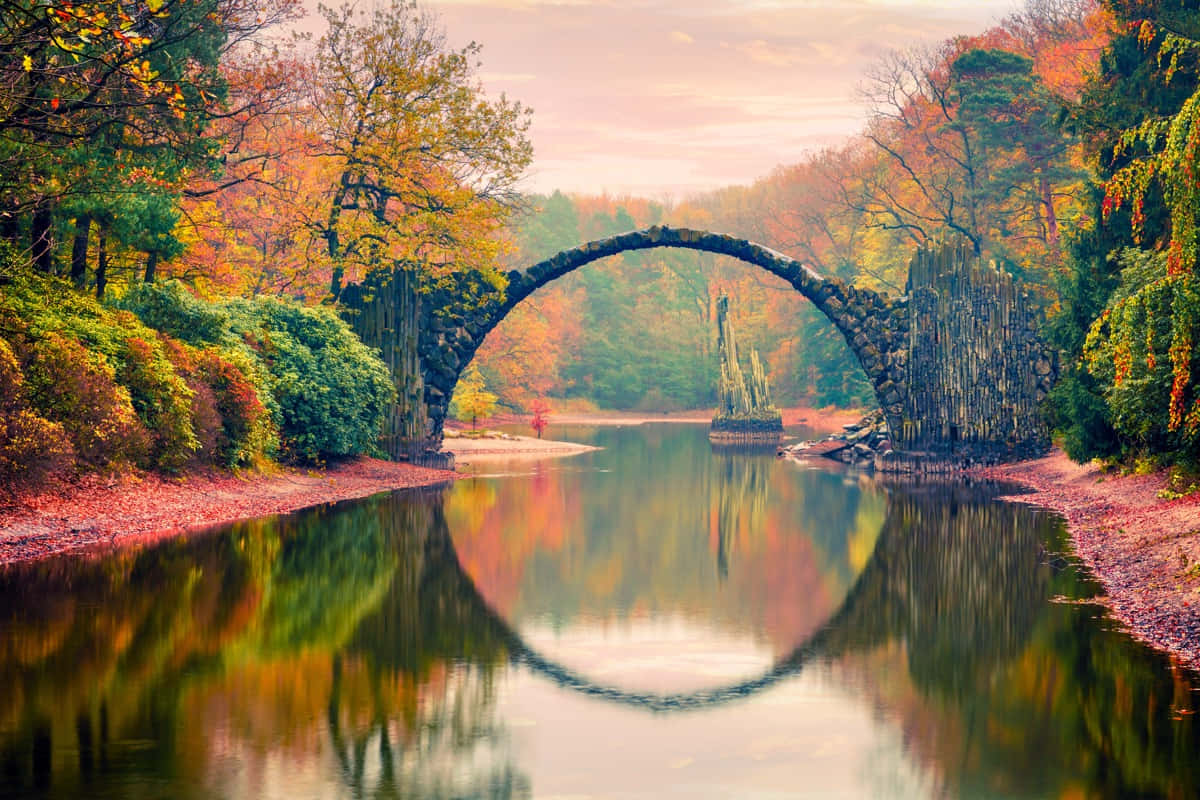 Stunning Fall Bridge Surrounded by Autumn Colors Wallpaper