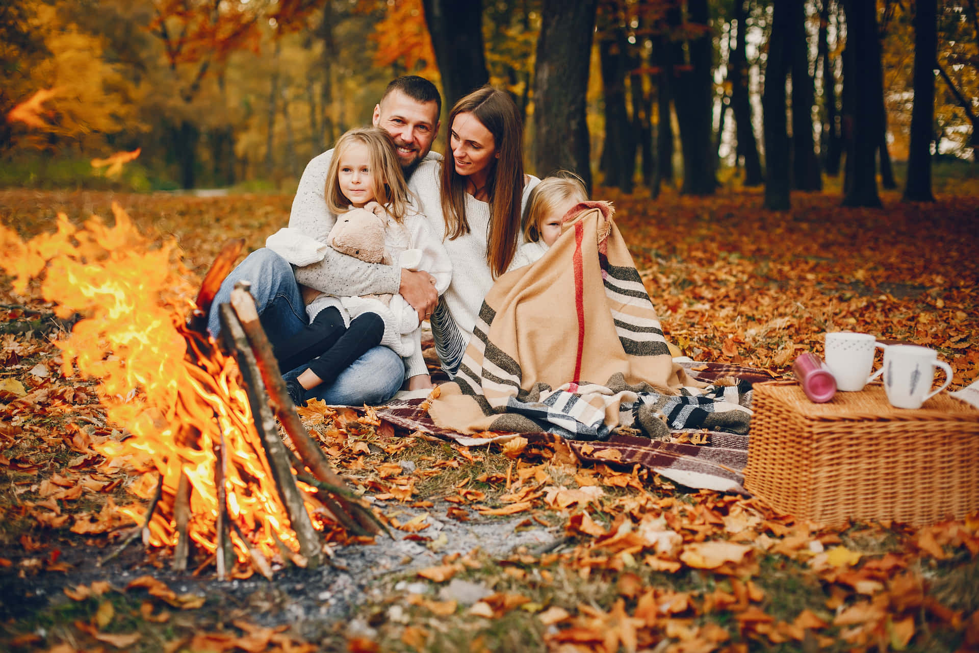 Family Having Fun Around A Campfire In The Autumn