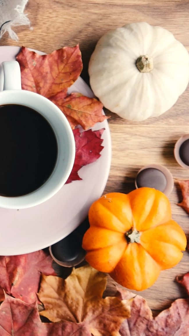 En kop kaffe med gourd og blade på et træbord Wallpaper
