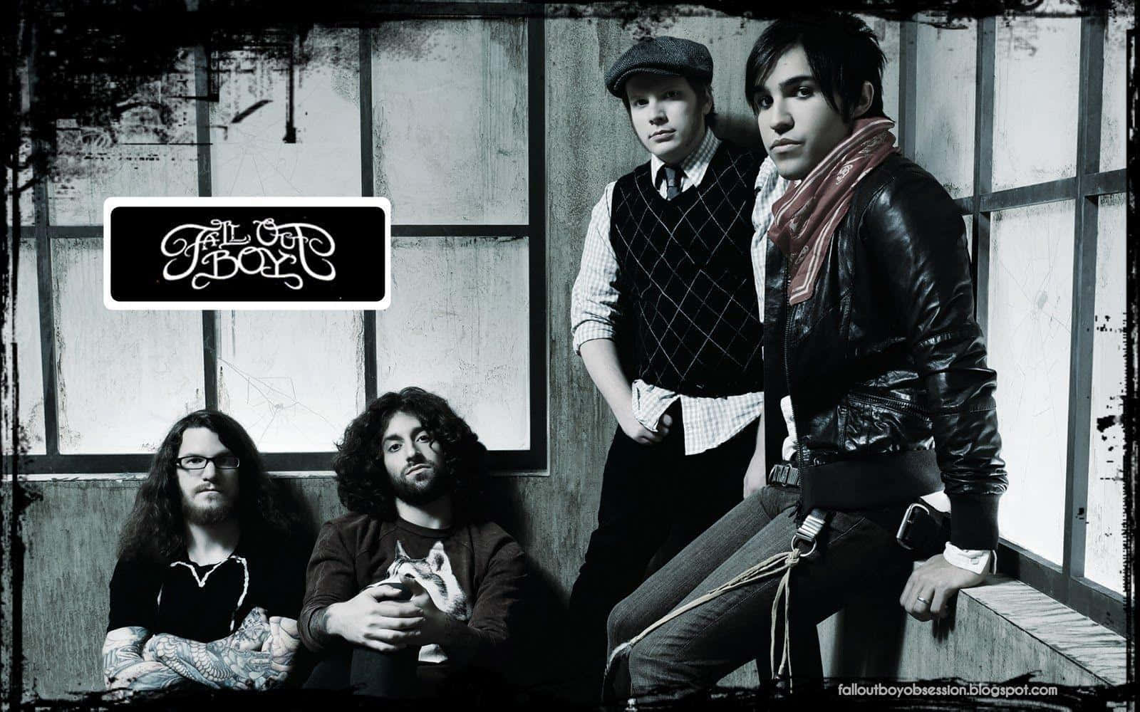 The Band Is Sitting On A Wall With A Sign Wallpaper