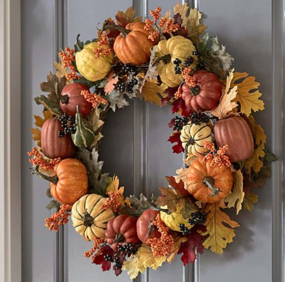Beautiful Fall Wreath Adorning a Rustic Door Wallpaper