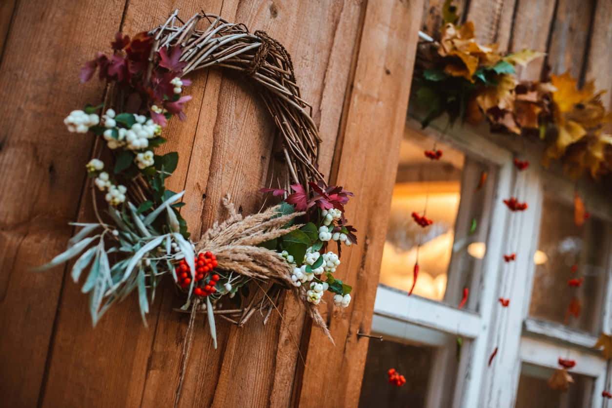 Vibrant Fall Wreath on Rustic Wooden Door Wallpaper