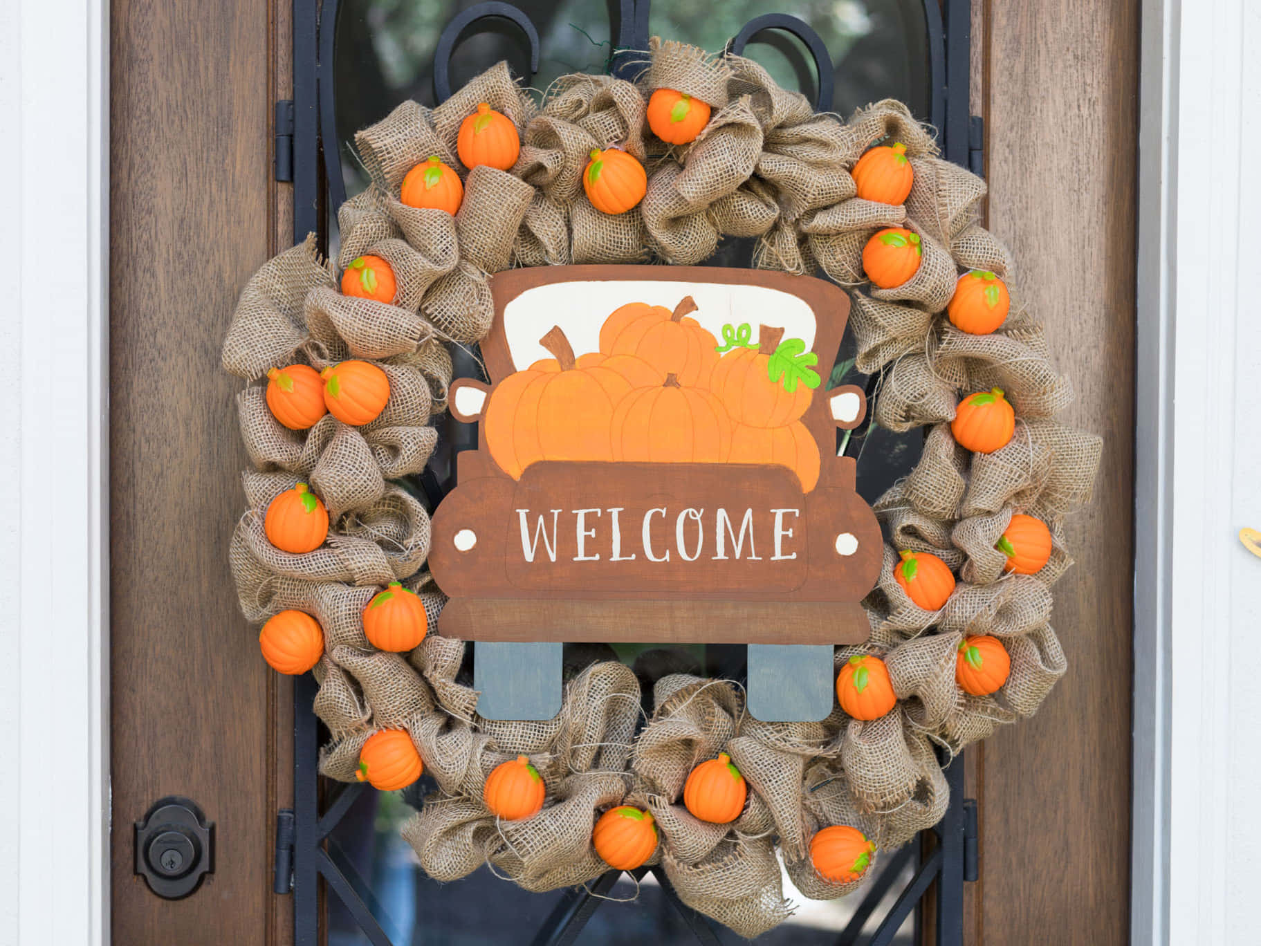 Vibrant and Colorful Fall Wreath Adorning a Rustic Door Wallpaper