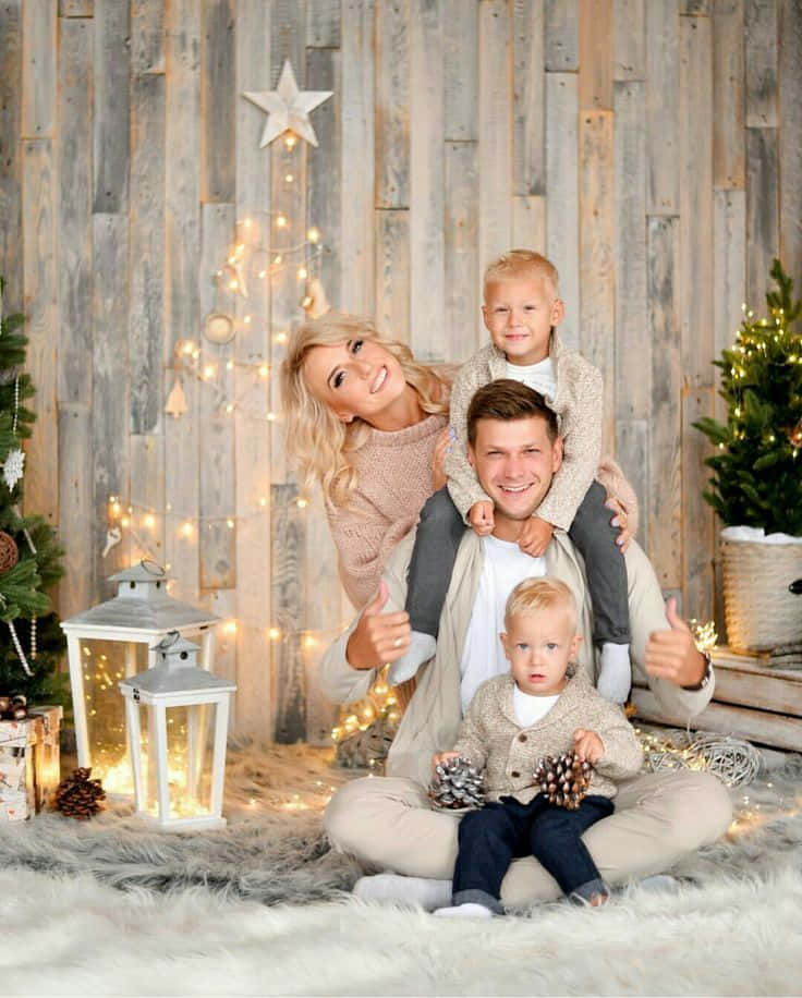 En familie tager et julefoto foran et juletræ