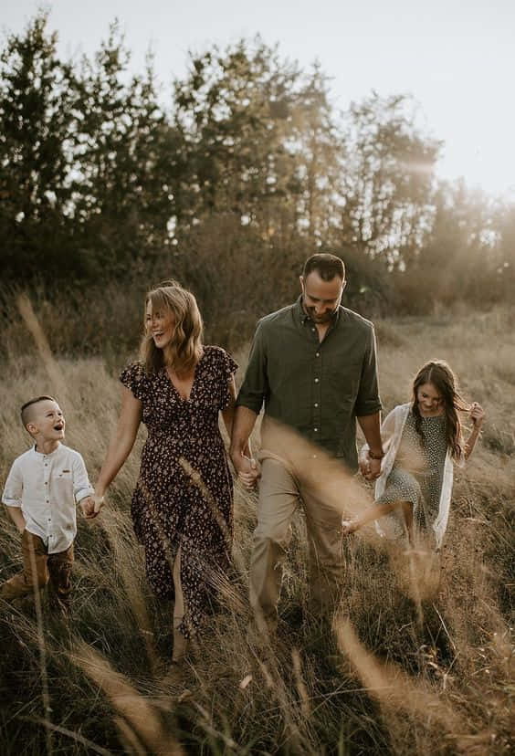 En familie på fem smiler sammen på en perfekt dag. Wallpaper