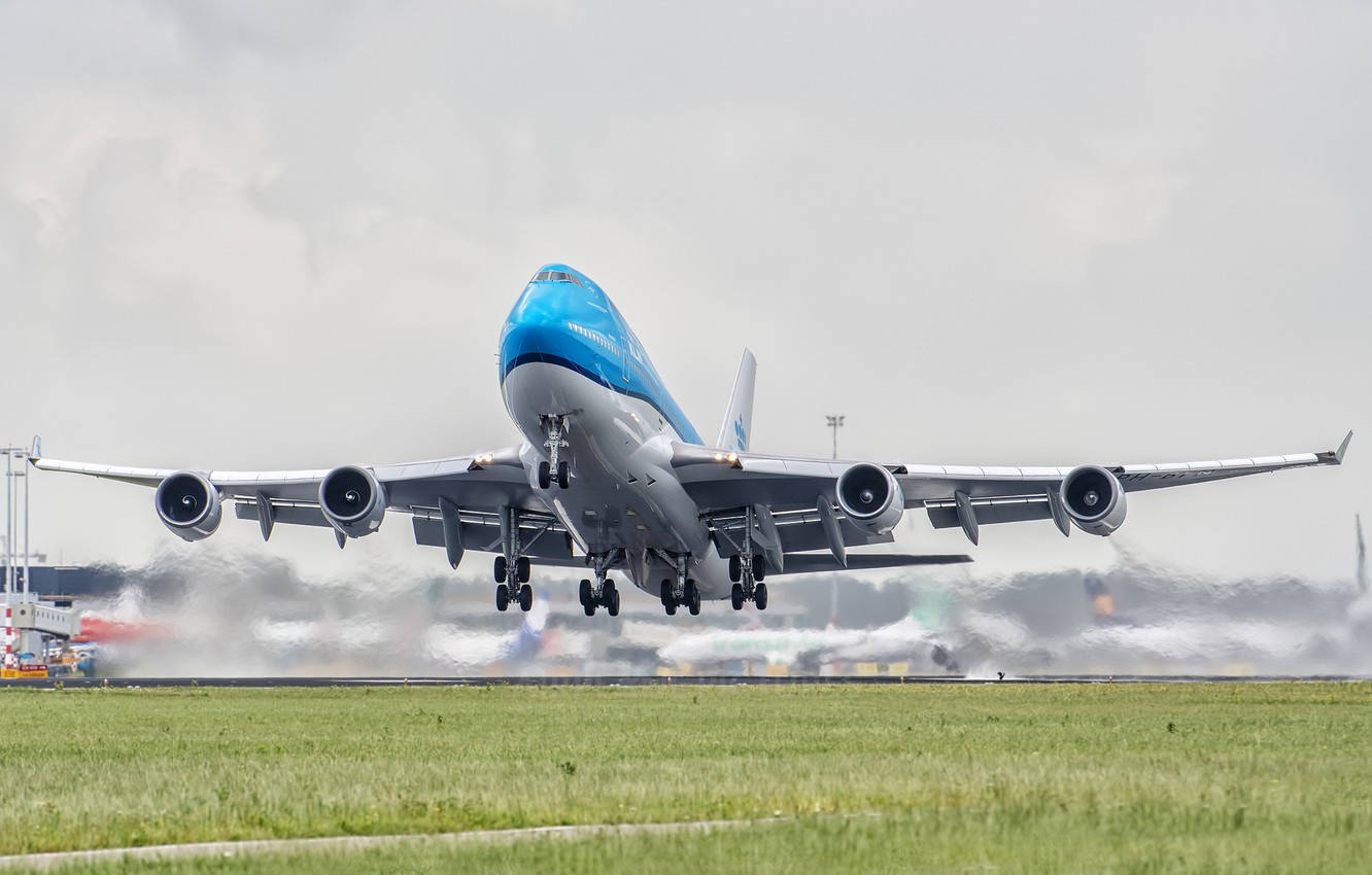 Fantastisk KLM Boeing Passage Plan flyver over den glødende bykulisse Wallpaper