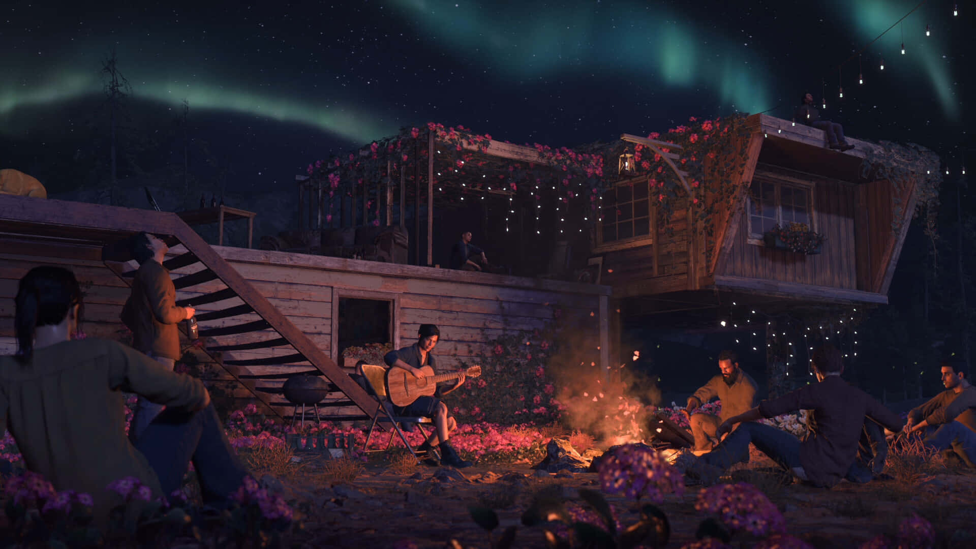 A Group Of People Are Sitting In Front Of A Cabin With Aurora Lights