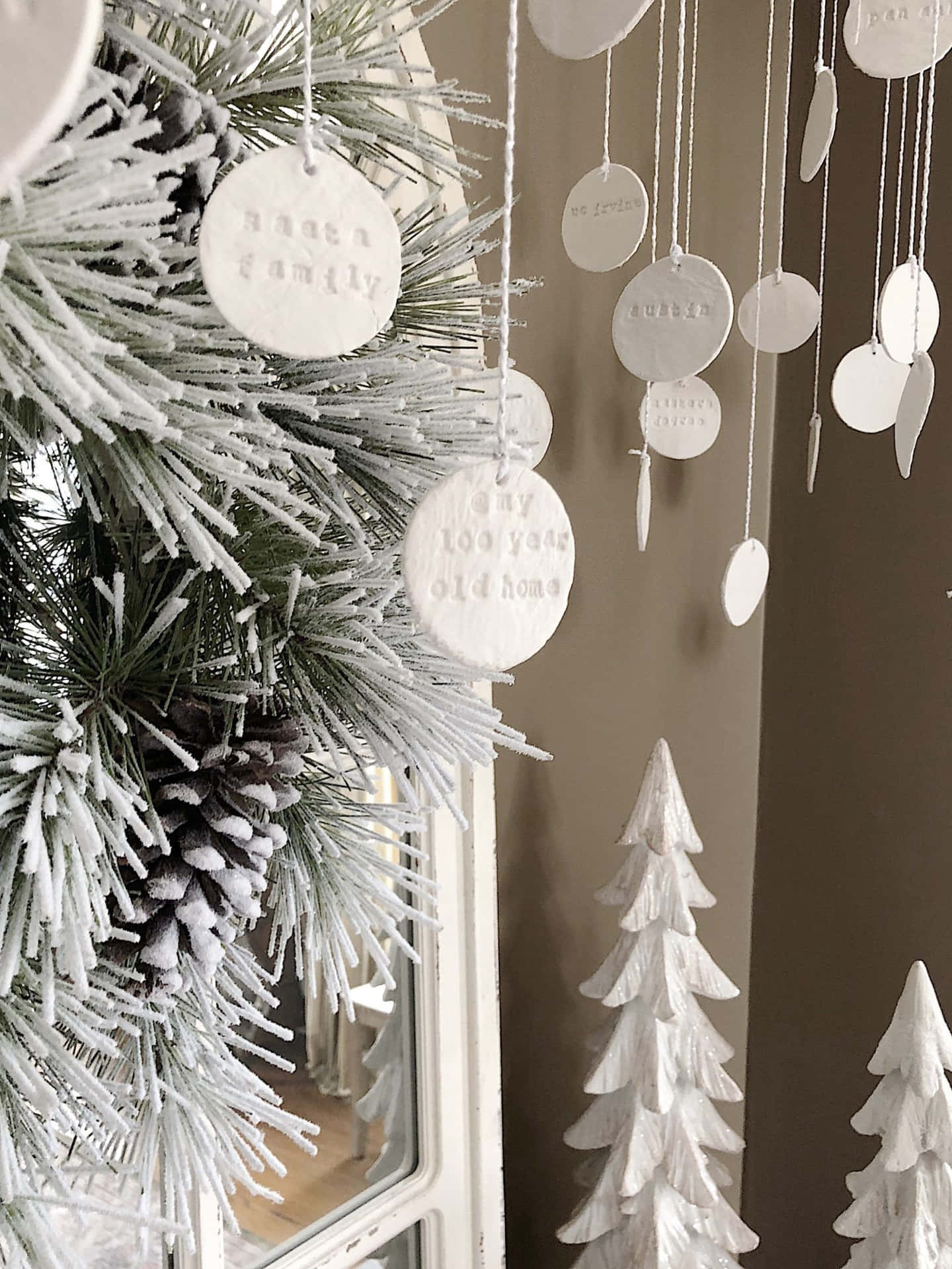 En juletræ med hvide dekorationer hængende fra det. Wallpaper