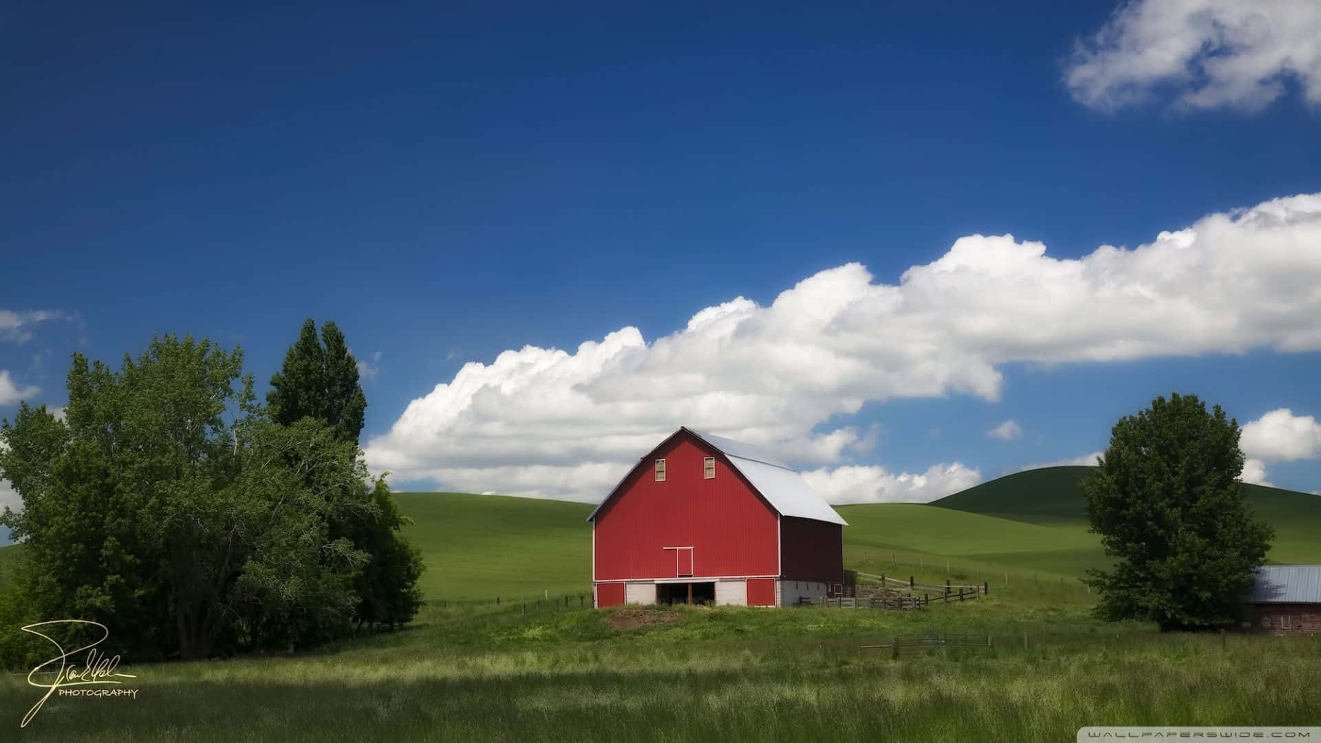 Einemalerische Landschaft Mit Sanften Grünen Hügeln, Ergänzt Durch Die Schönheit Eines Gemütlichen Bauernhauses. Wallpaper