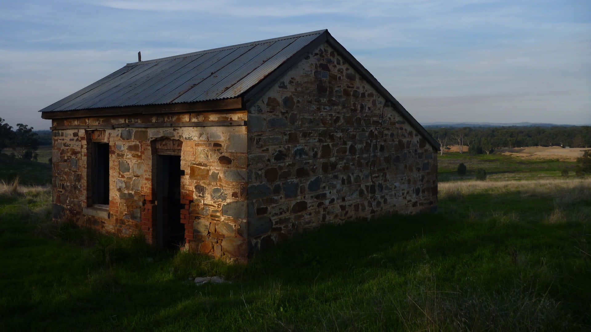 An Old Stone Building In A Field Wallpaper
