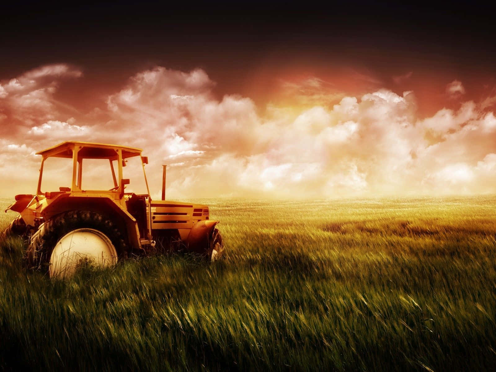 A Tractor In A Field With A Sunset Behind It Wallpaper