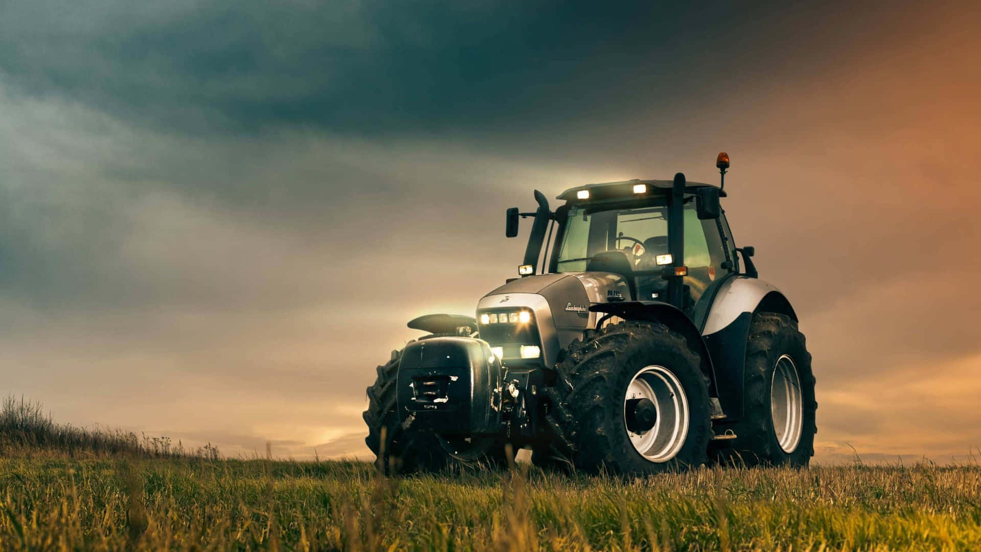 A Tractor Is Parked In A Field With A Cloudy Sky Wallpaper