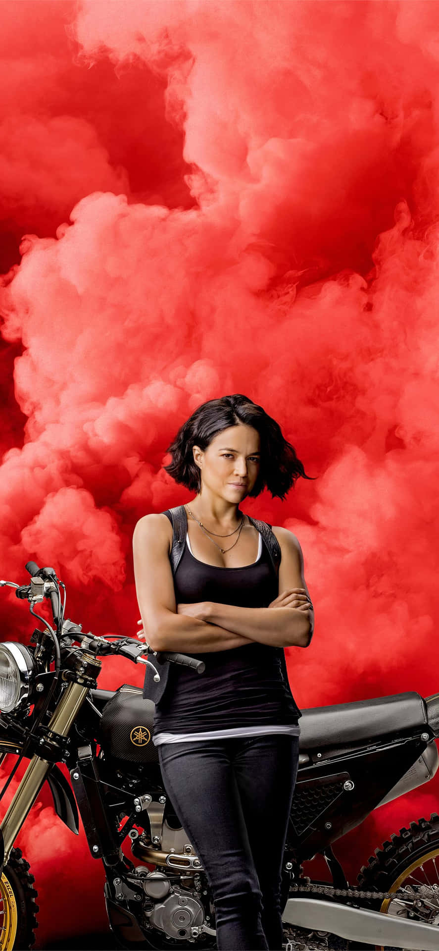 En kvinde stående ved siden af ​​en motorcykel Wallpaper